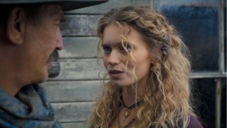 Abbey Lee stands in conversation with Kevin Costner in the street in Horizon An American Saga.