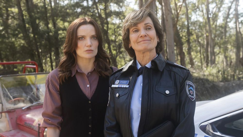 Anna Samson as Detective Inspector Mackenzie Clarke and Catherine McClements as Senior Sergeant Philomena Strong standing next to each other in an episode of Return to Paradise