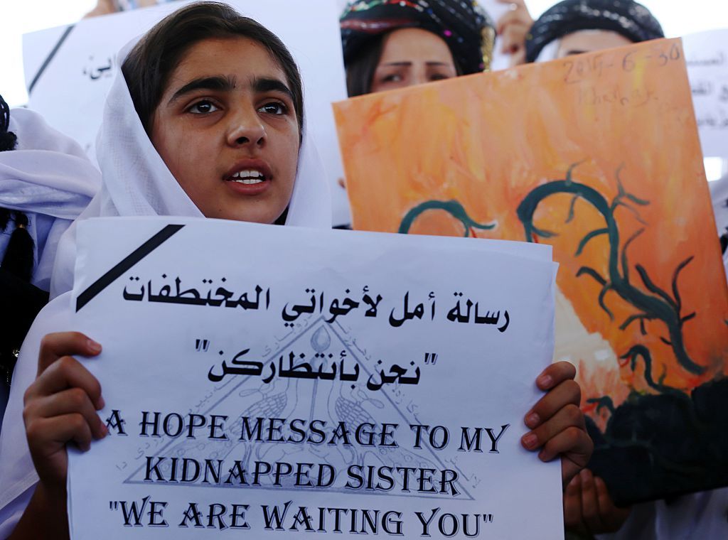 An Iraqi Yazidi woman holds a sign in Erbil, in Iraqi Kurdish territory