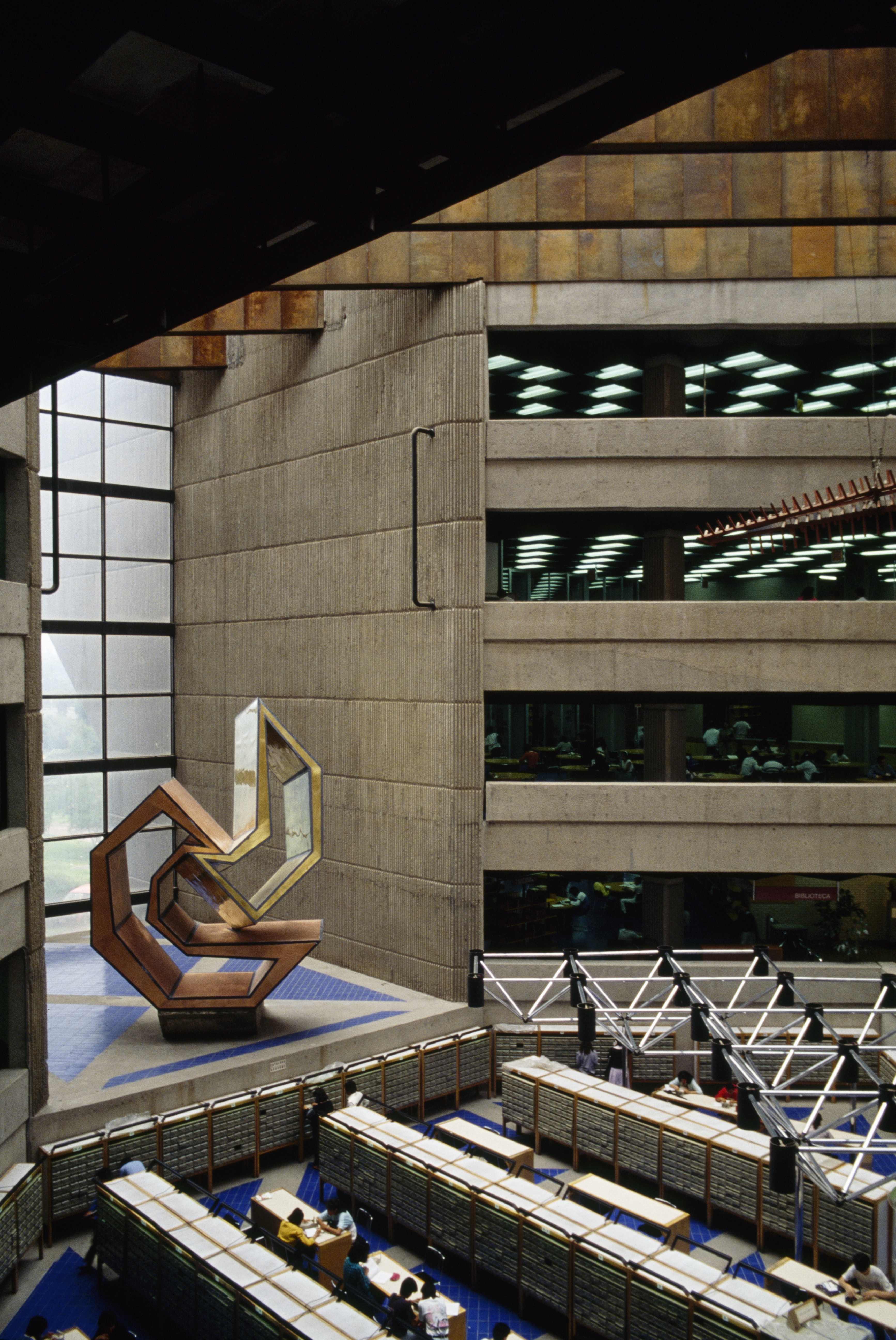A university library set within a brutalist, modernist building.