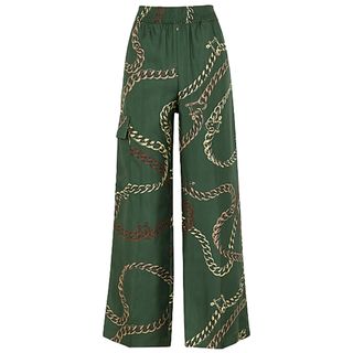 wide legged green based trousers with muted neutral chain print