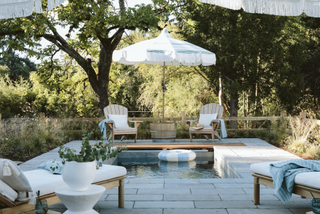 plunge pool in garden with white sun loungers