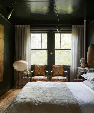 Bedroom with dark green walls, dark green glossy ceiling, large windows and neutral decor