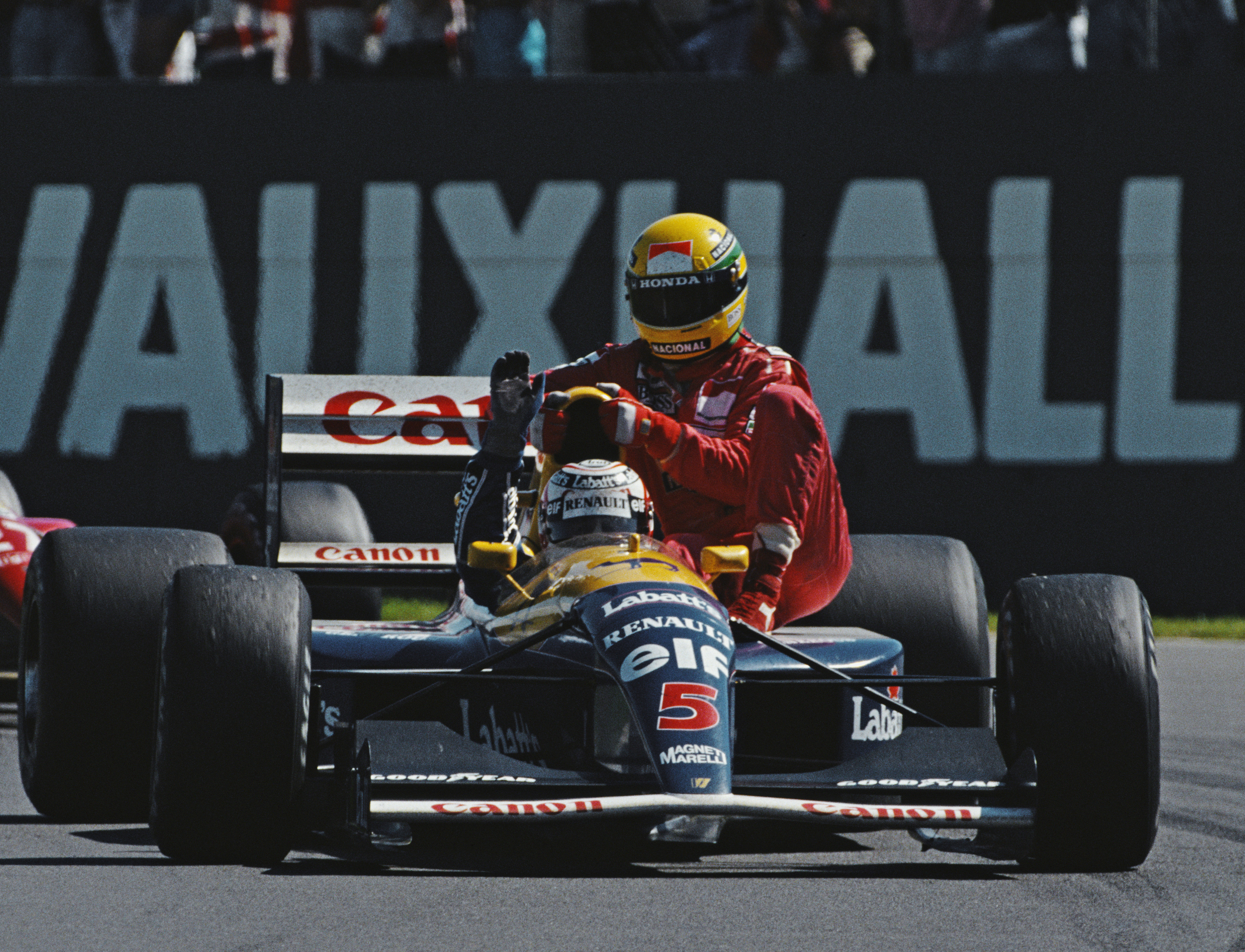 Nigel Mansell gives Ayrton Senna a ride back to the pits after he had run out of fuel during the British Grand Prix
