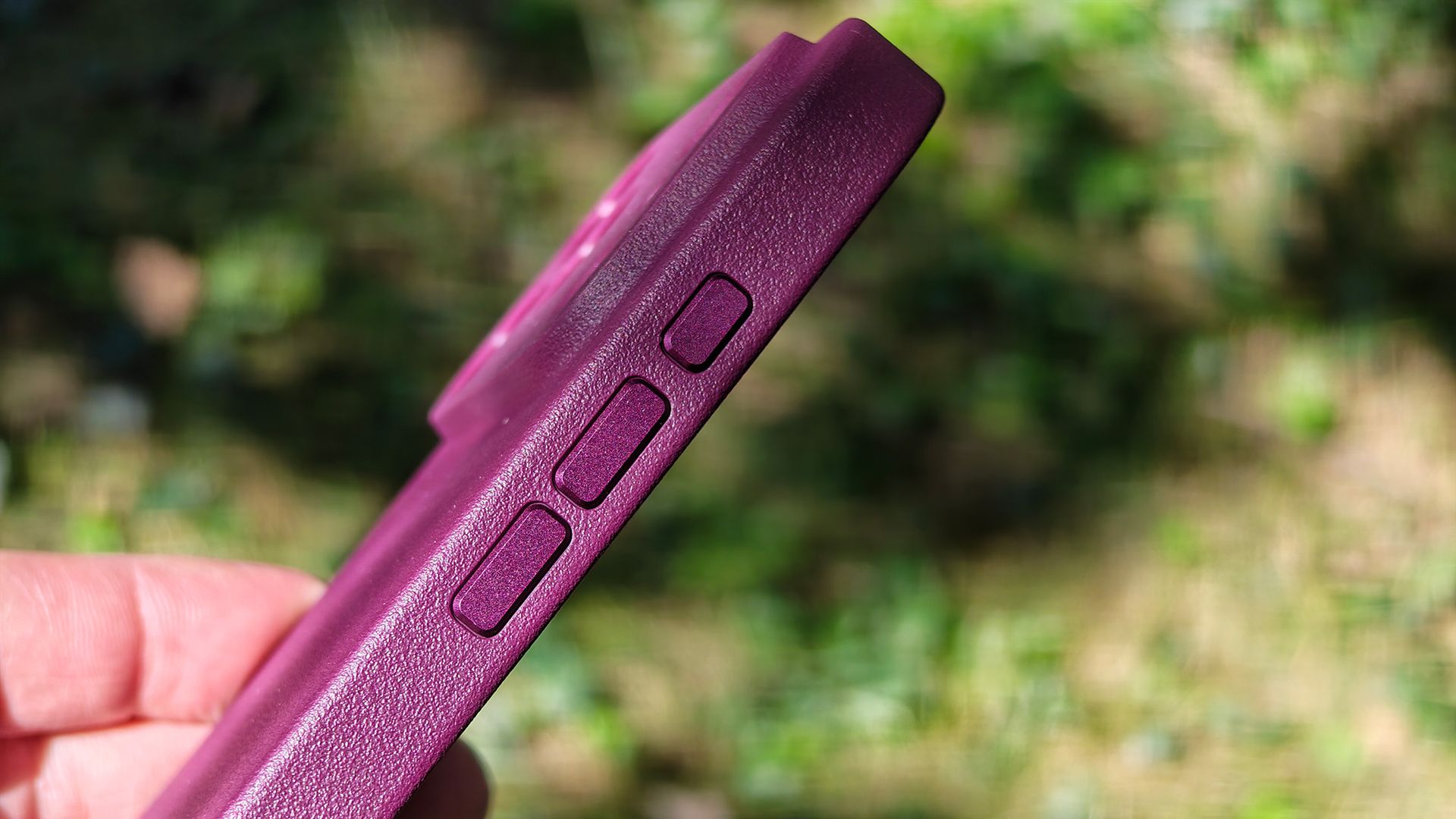 A burgundy Dbrand MNML case on an orange Apple iPhone 17 Pro Max
