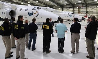 National Transportation Safety Board investigators are seen with Virgin Galactic's WhiteKnightTwo, the carrier plane for the SpaceShipTwo spacecraft, at the private spaceflight company's hangar in Mojave, California.