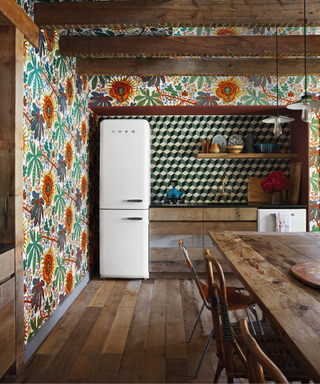 kitchen with floral wallpaper and retro style fridge with wooden dining table