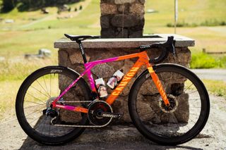 Canyon Sram custom orange and pink bike side on against a stone wall