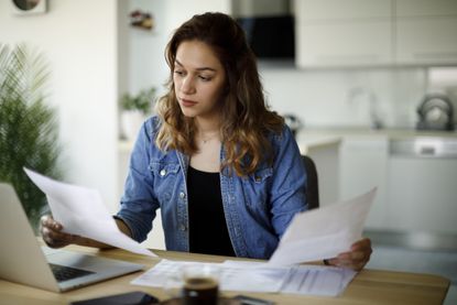 A young woman looks at her pension statement (image: Getty Images)