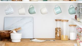 organizing kitchen countertops with hooks secured under cabinets to store mugs