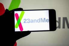 In this photo illustration, a 23andMe logo seen displayed on a smartphone and in the background.