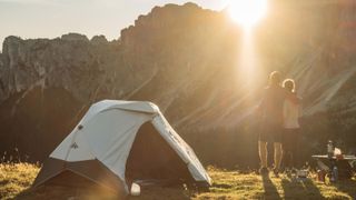 Couple camping in mountains with pop-up tent