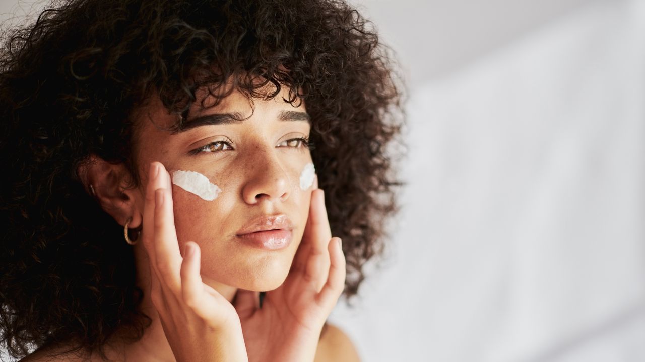 Woman applying moisturiser