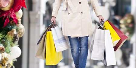 young woman walking with shopping bags in hands, christmas background