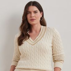 Brunette young woman in her thirties wearing white cable-knit cricket sweater by Ralph Lauren.