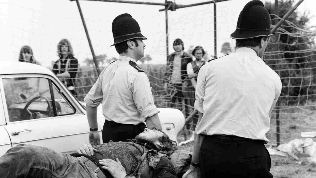 Police carrying a Hells Angel member on a stretcher at the Weeley festival