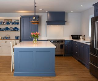 blue shaker kitchen with large kitchen island with white worktop