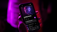 Deezer shot of a person holding a phone with AI generated content 