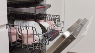 Open dishwasher with clean load showing third drawer