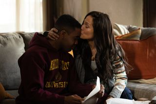 A woman (Jennifer Lopez, right) kisses her son (Jharell Jermone, left) on the forehead as they sit on a living room couch, in 'Unstoppable.'