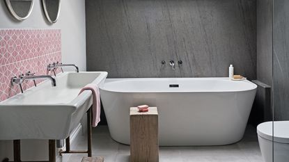 gray bathroom with white tub and large sink