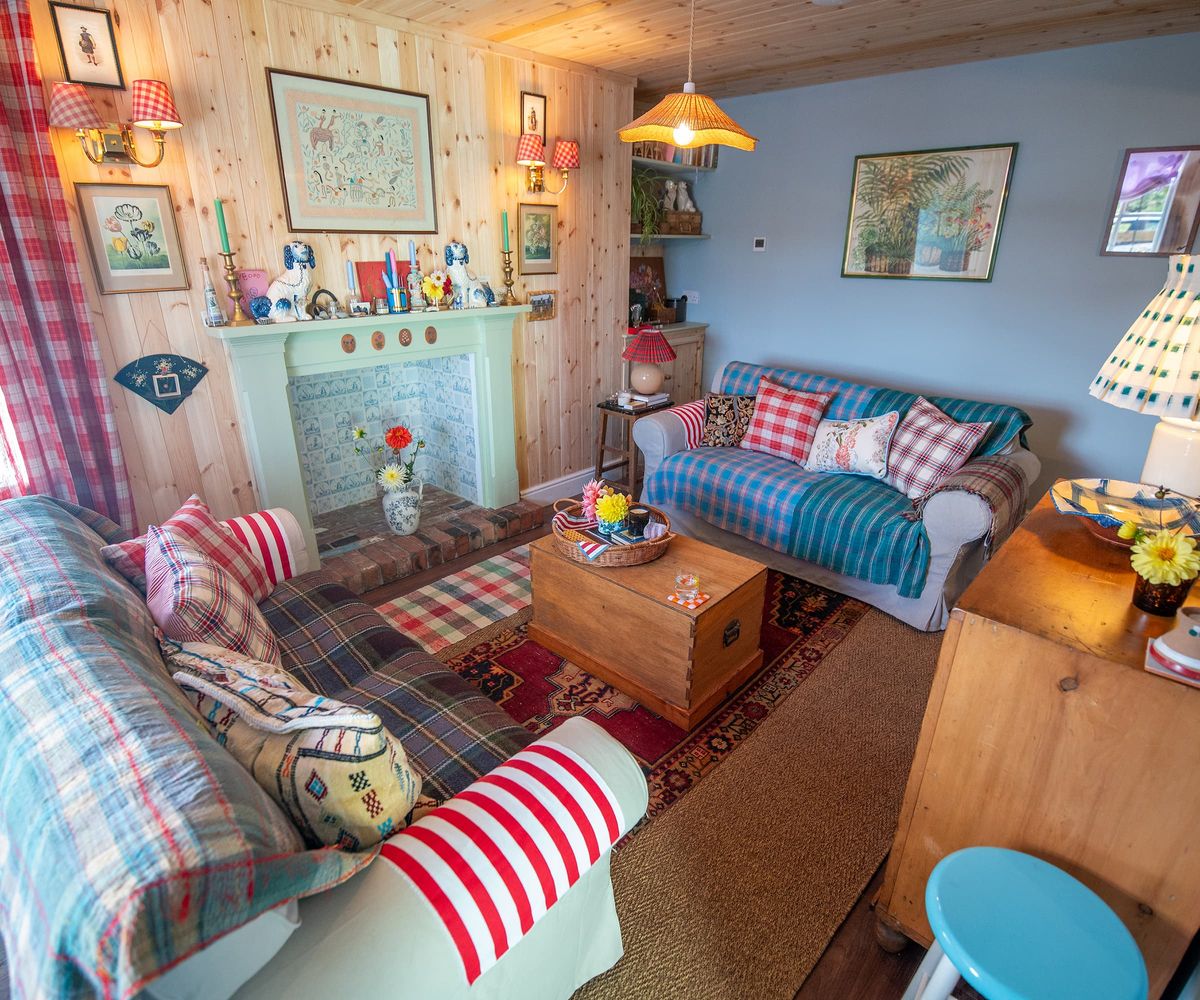 A living with a light blue fireplace, tartan carpet and wood panelled fireplace surround
