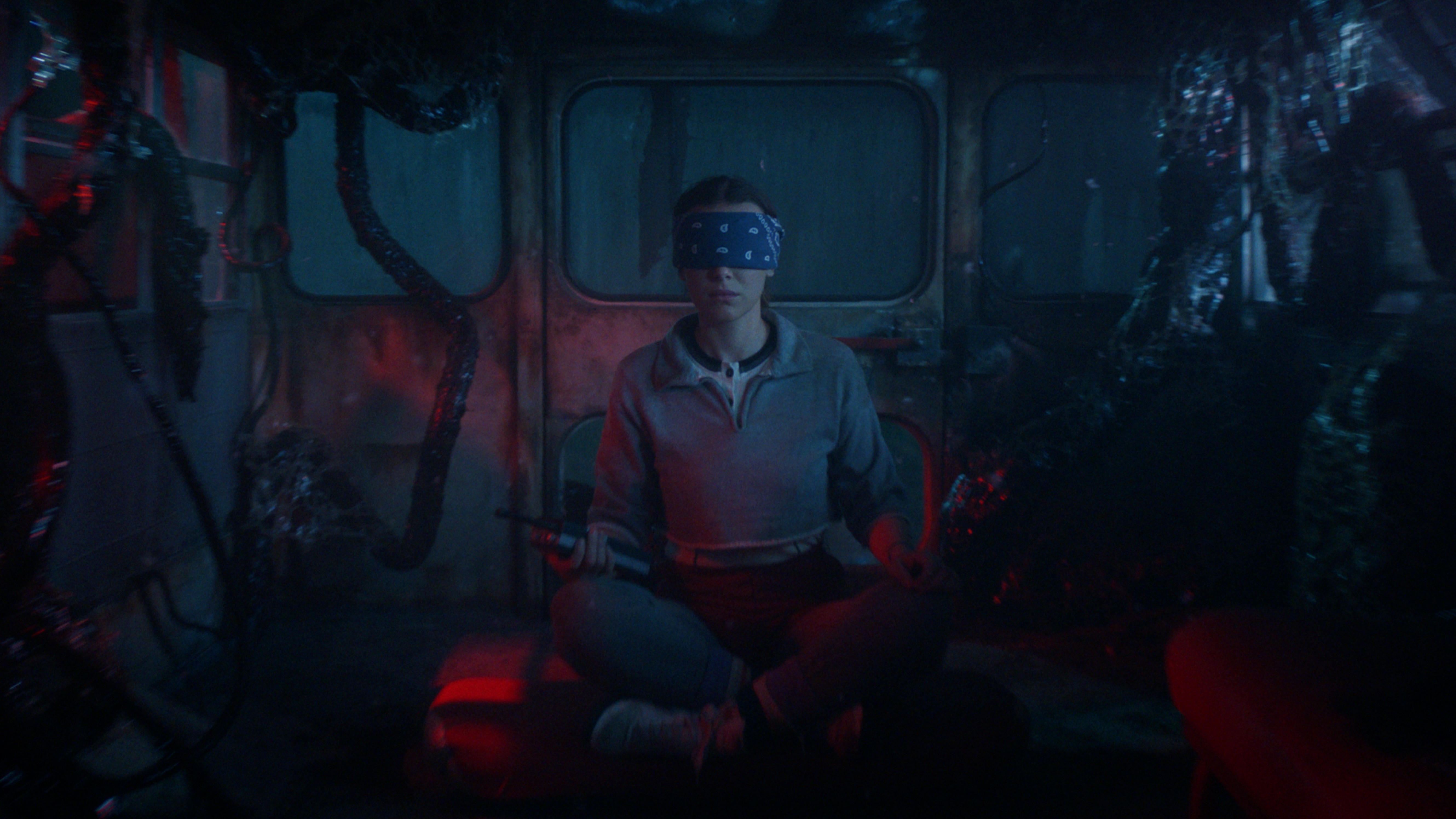 Eleven (Millie bobby Brown) meditates in a van in the Upside Down in "Stranger Things" season 5