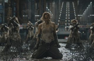 a group of women (with jennifer lopez in the center) are dressed in work clothes and covered in grime as they kneel in mud inside of a factory