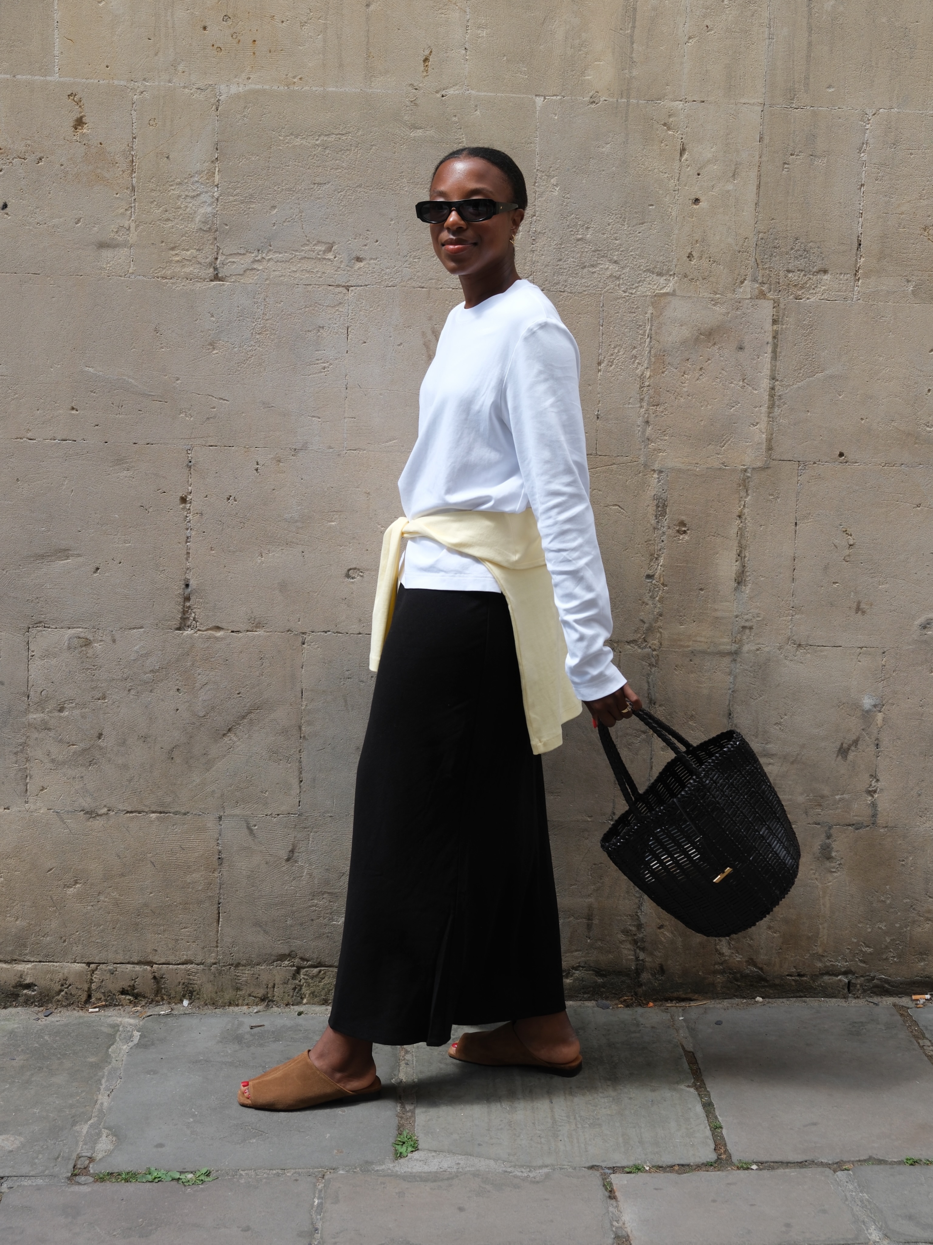 Influencer Taffy Msipa wearing a long sleeve t-shirt, satin skirt and suede mules.