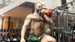 Glenn Luff doing kettlebell lunges in a gym
