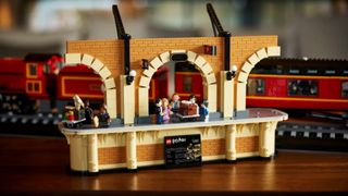 Lego Hogwarts Express minifigures on a platform, with the train in the background