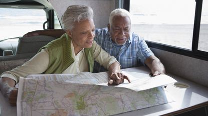 A retired couple look over a map in an RV.