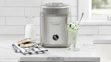 Cuisinart Ice Cream Maker on a marble countertop with ice cream and ice cream sandwiches around it