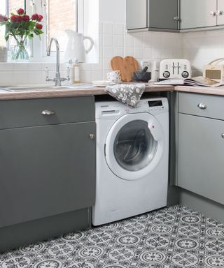 Grey kitchen with patterned flooring, white washing machine and tiled splashback