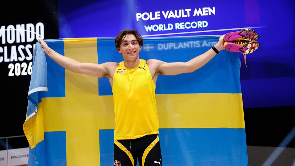 Mondo Duplantis poses with the Sweden flag after breaking the men's pole vault world record