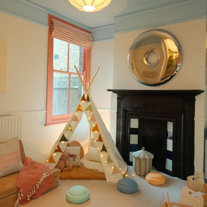 Zac's playroom designed by Tash Bradley with a blue ceiling, an earthy red-painted window frame and a white teepee tent