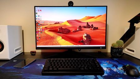 A black Philips Evnia 27M2N3800A gaming monitor on a black desk