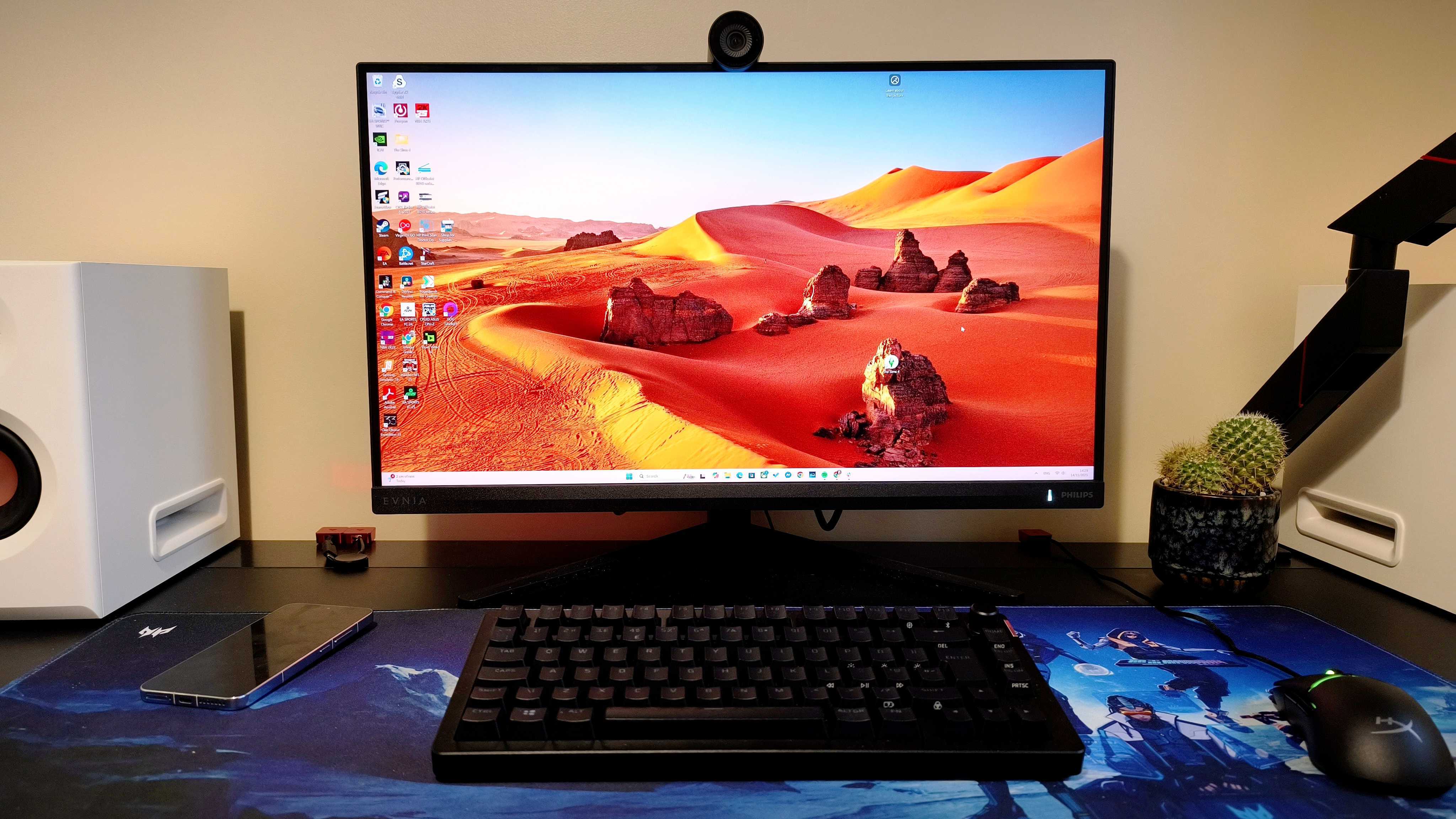 A black Philips Evnia 27M2N3800A gaming monitor on a black desk