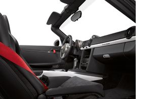 Black interior of the car, with red seatbelts and door pulls