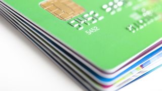 A stack of six credit cards and the top card is green