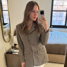 A photo of Nikki chwatt wearing a plaid blazer and skirt.