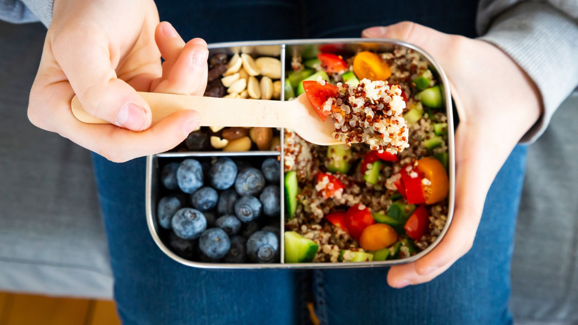 Healthy snacks in box, including blueberries and quinoa salad