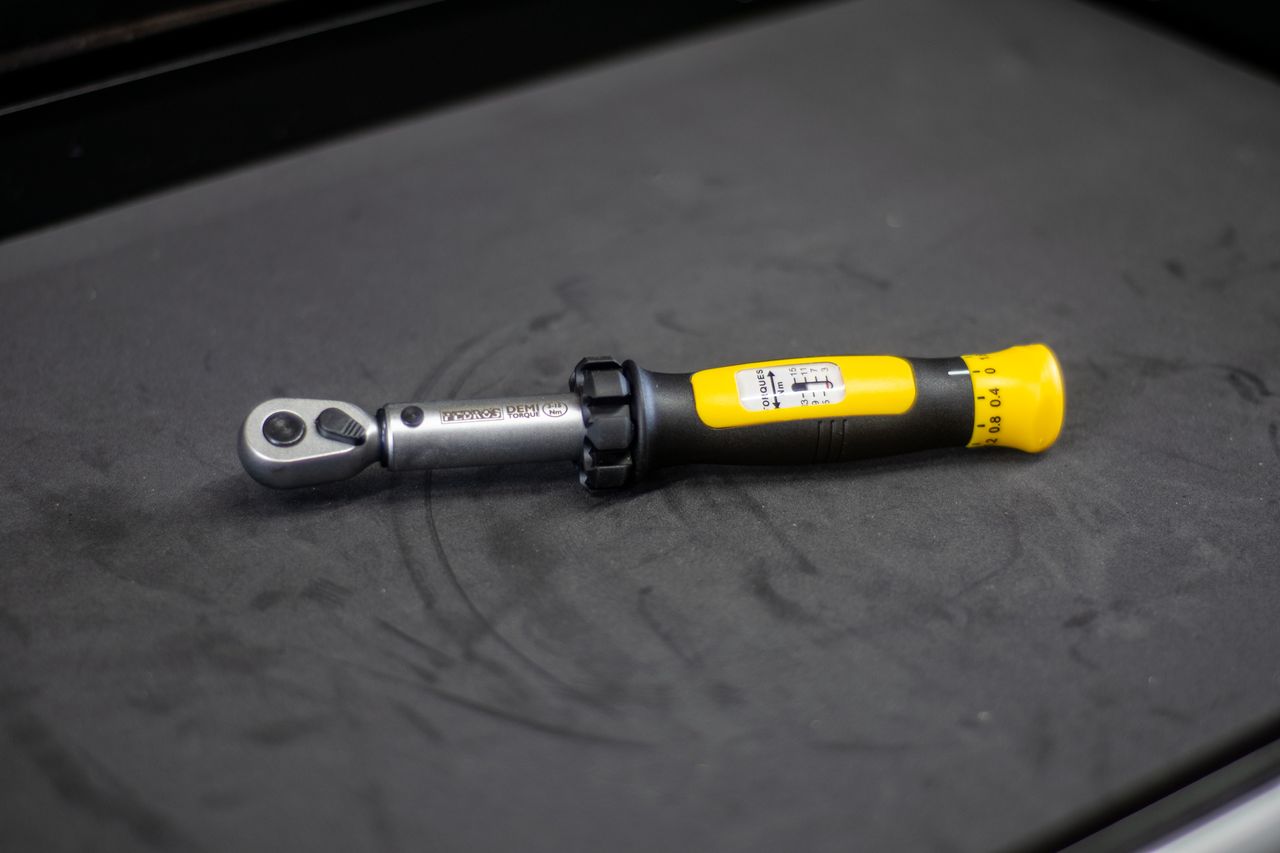 A Pedros Demi II torque wrench on a black workbench