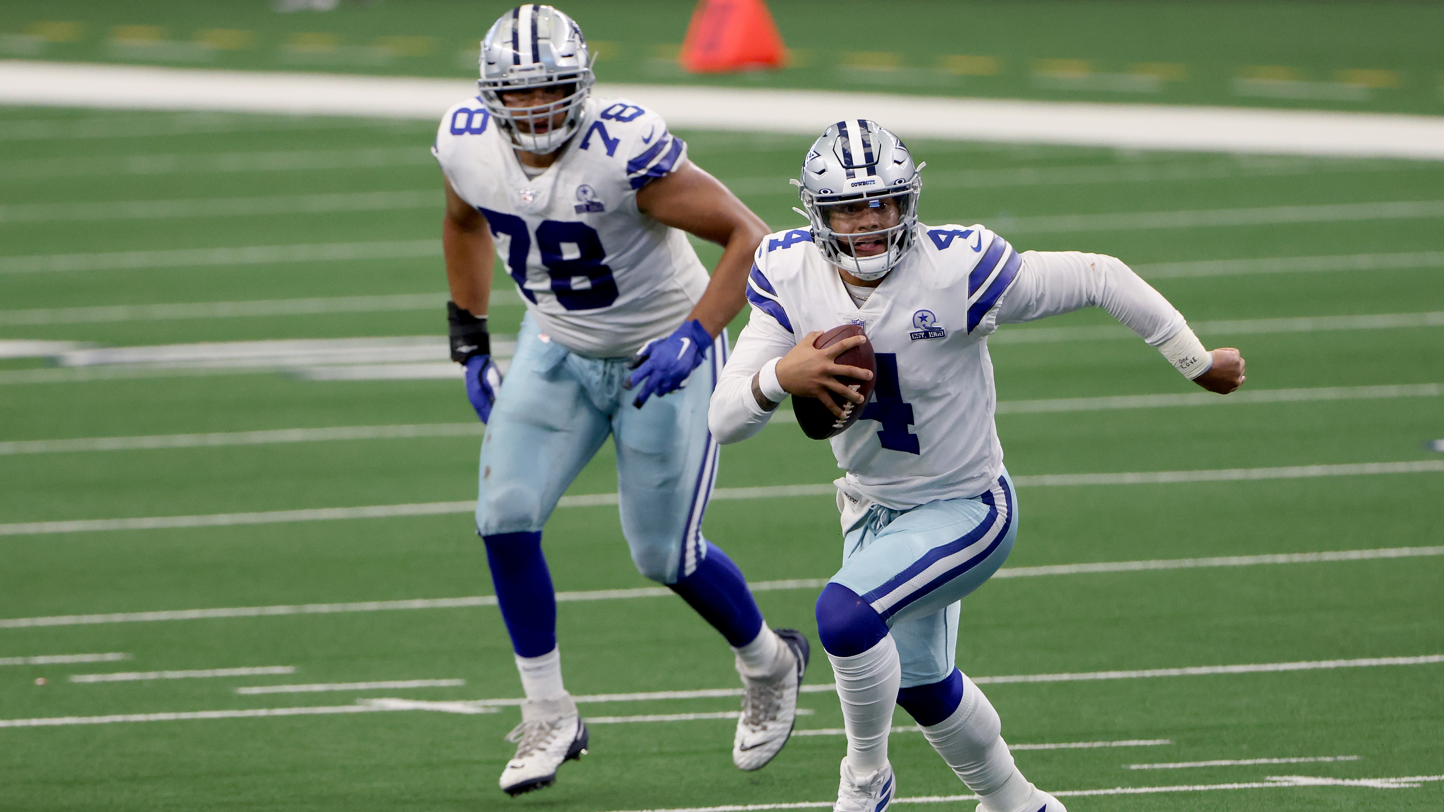 Dallas Cowboys quarterback Dak Prescott scrambles with the ball in hand