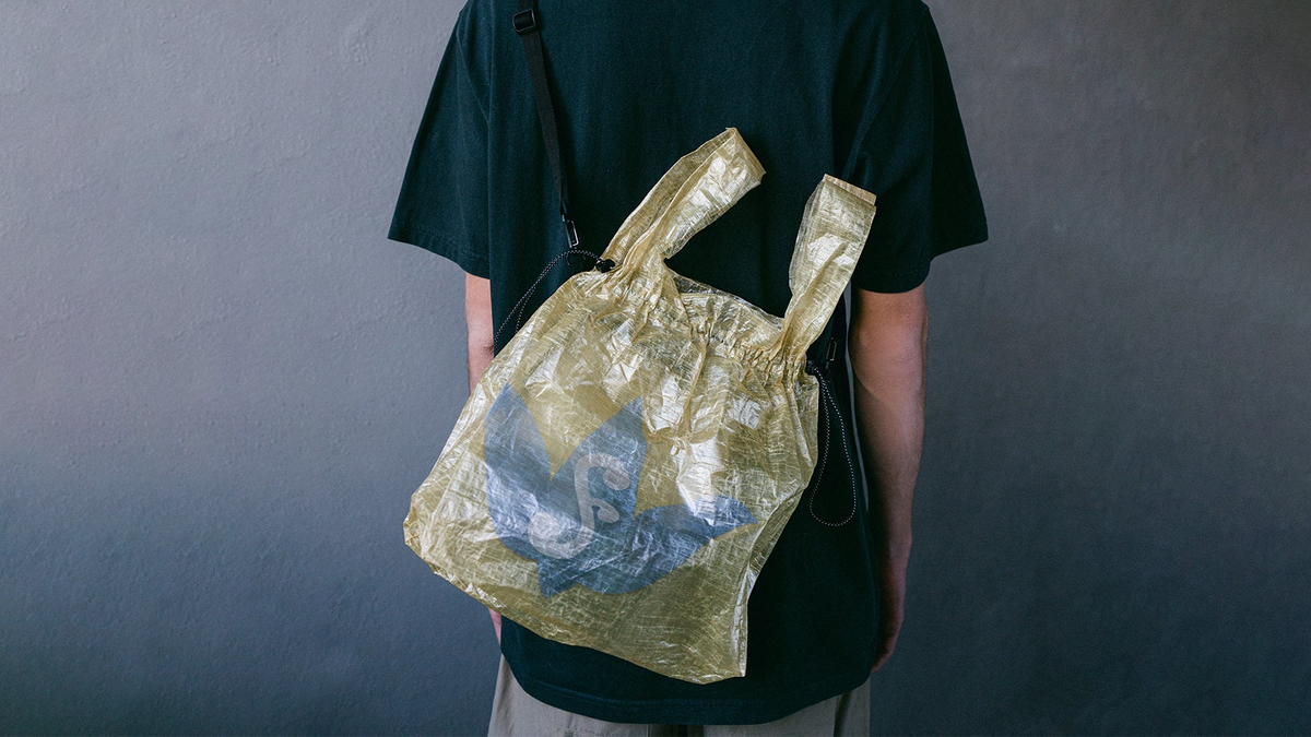 A very expensive yellow carrier bag, worn on a faceless model&#039;s back.