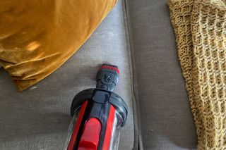 Henry Quick vacuum with 2-in-1 tool using on grey sofa