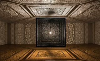 A large-scale shadow box comprised of Moorish patterns, suspended in the middle of a room