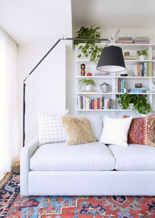 White sofa in a living room with white bookshelves behind