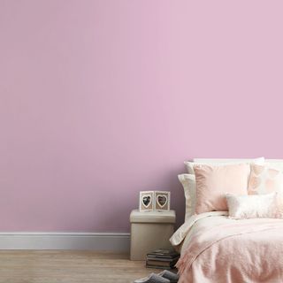 pink bedroom wall with bed