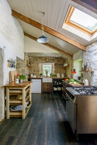 Rustic stone farmhouse kitchen design with freestanding furniture